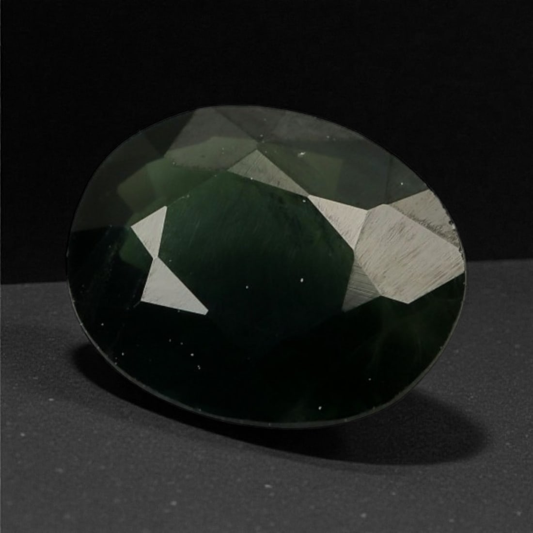 1.18 Carats Forest Green Sapphire - Natural Sri Lankan Stone - 7.1 x 5.8 x 3.1 mm, 70WE: This deep forest green sapphire reveals a moody elegance with rich saturation and subtle variations in tone that emerge under shifting light. Its oval cut displays a subdued luster, allowing the stone