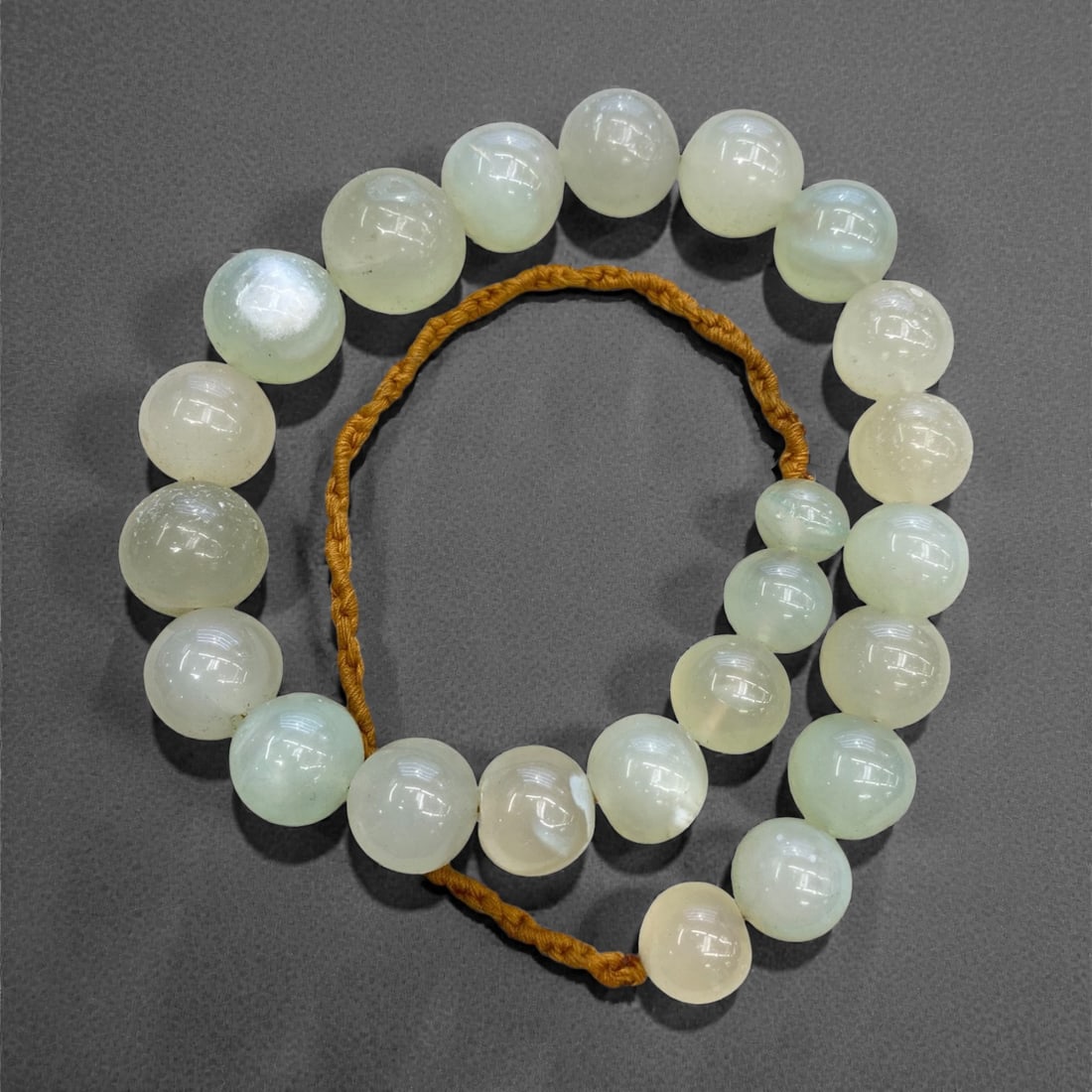 An Antique Indian Chalcedony Bead Necklace Strand, 19th Century, 282g, 35AA: Composed of graduated spherical chalcedony beads in translucent pale green and milky white hues, strung on a period braided fiber cord. Chalcedony has been revered in India for centuries for its soft,