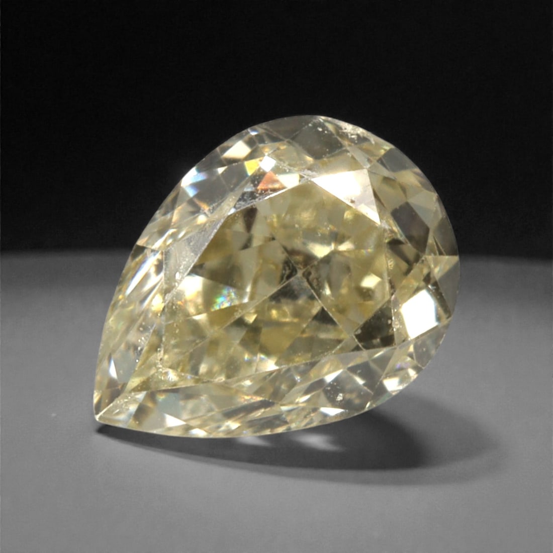 0.30 Carats Fancy Light Yellow Diamond - Natural South African Origin, 36DA: This 0.30 carat fancy light yellow diamond glows with a soft, buttery hue reminiscent of sun-warmed honey, its pear brilliant cut amplifying a lively, luminous sparkle across every precisely polished