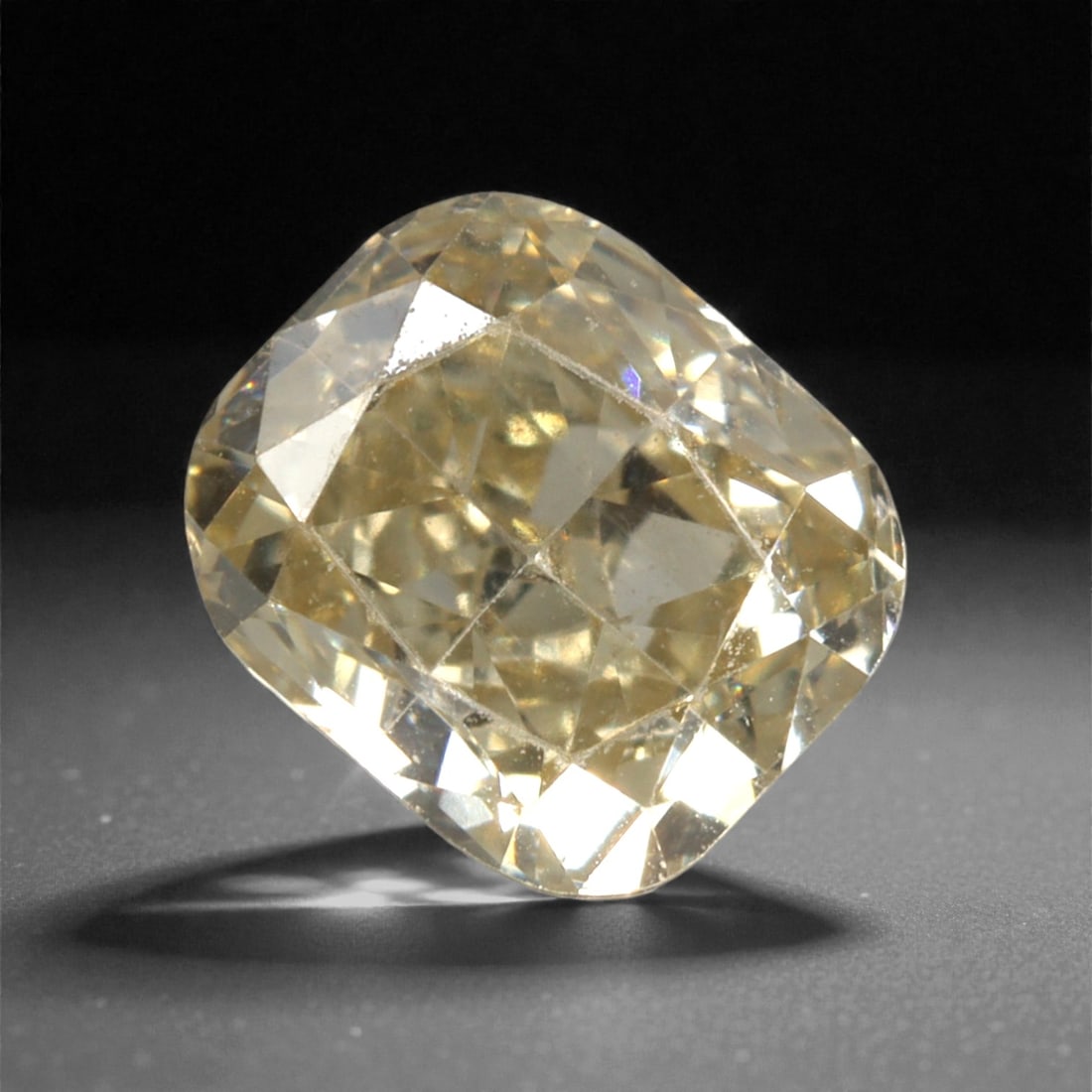 0.39 Carats Fancy Light Yellow Diamond - Natural South African Origin, 42DA: This 0.39 carat fancy light yellow diamond glows with a warm, buttery hue reminiscent of sunlit honey, its cushion modified brilliant cut amplifying a luminous, lively sparkle across every precisely p