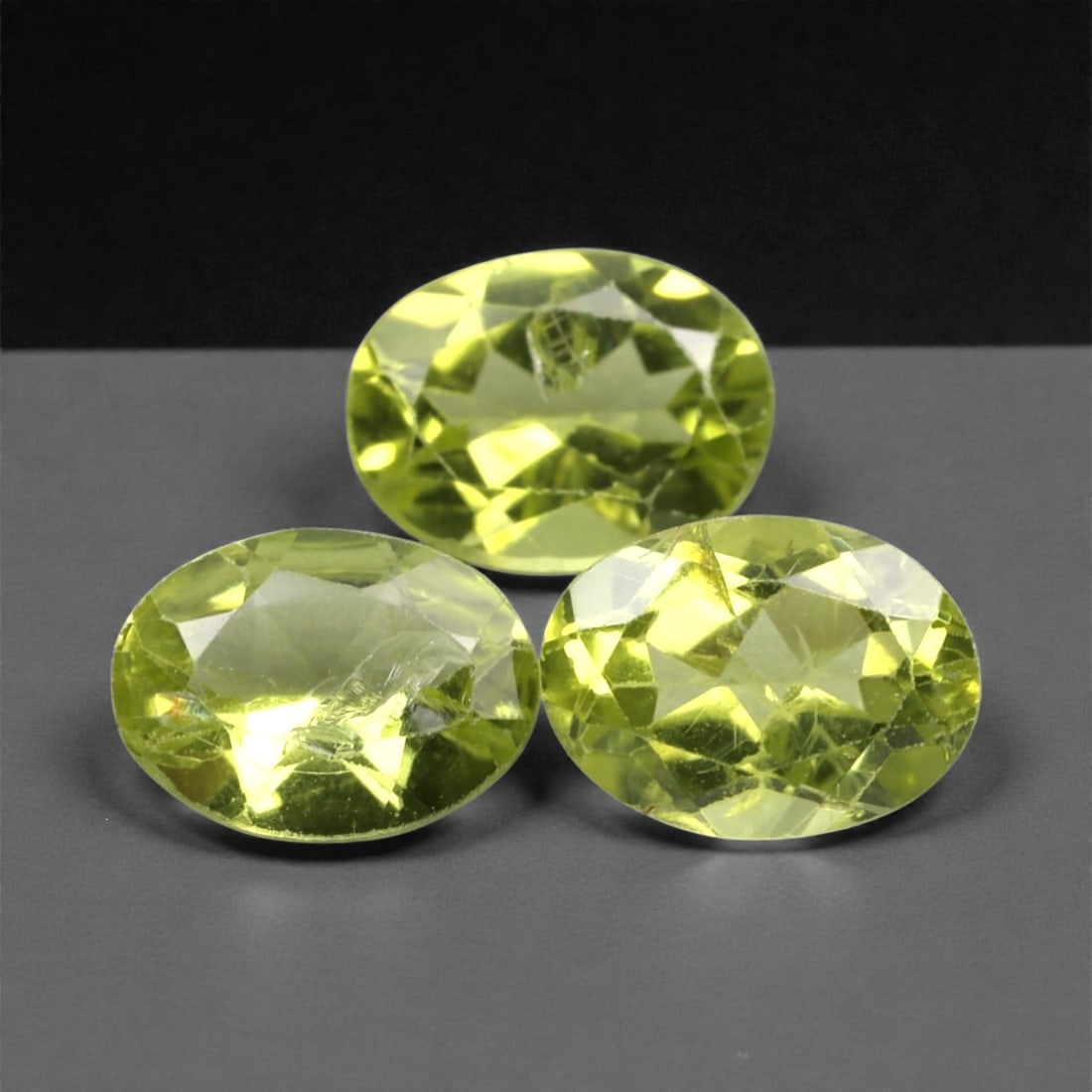 3.85 Carats Bright Green Peridot Selection - Natural Pakistani Stones, 309A: This curated selection of three oval-cut peridot gems radiates with a vibrant, lime-green hue, evoking the lush vibrancy of sunlit tropical foliage. Each stone is precision-faceted to maximize light d