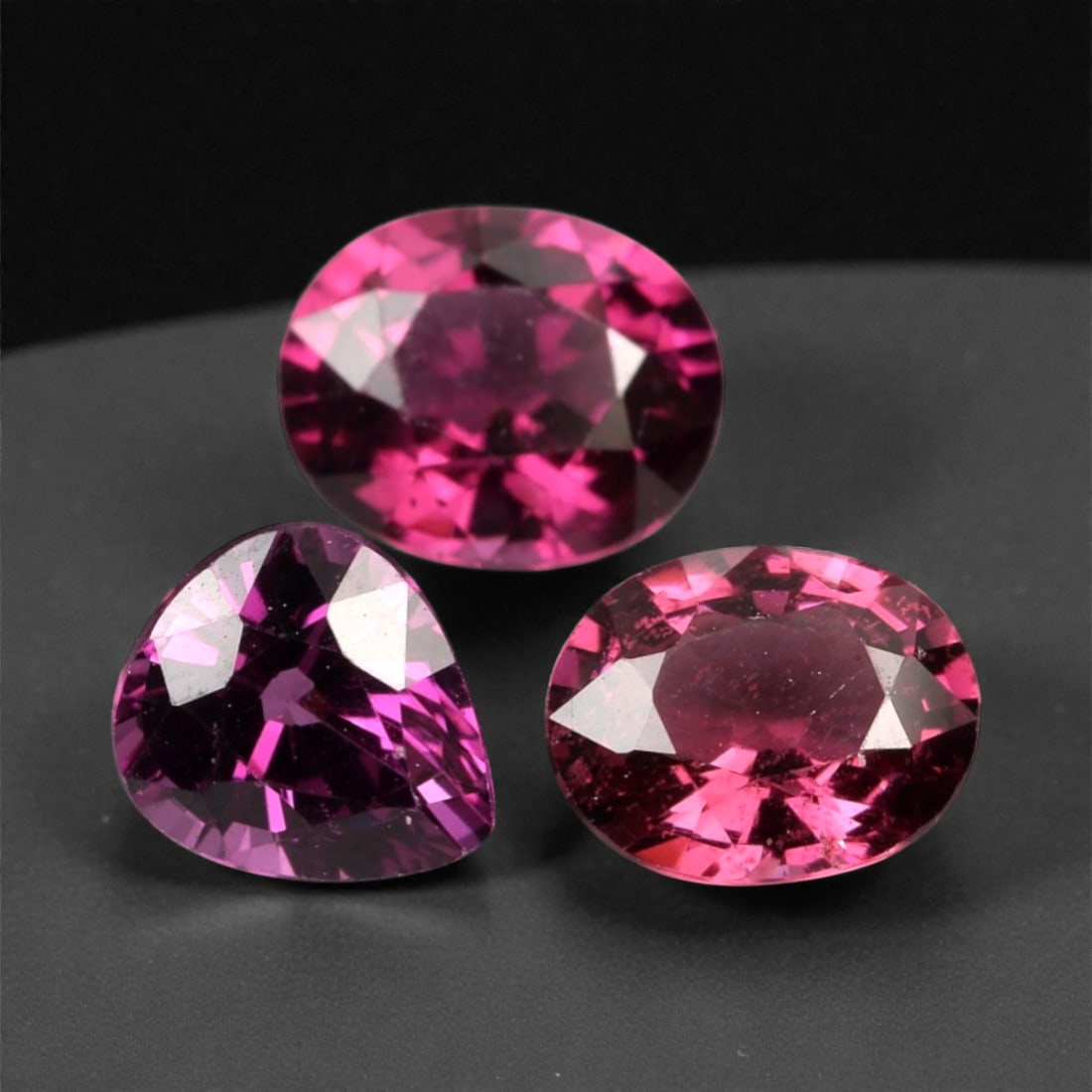 3.20 Carats Deep Raspberry Rhodolite Garnet Selection - Natural Mozambican Stones, 363A: This curated selection of three rhodolite garnets captivates with a deep, velvety raspberry hue, reminiscent of ripe summer berries and rich red wine. Each stone is precision-faceted to maximize light