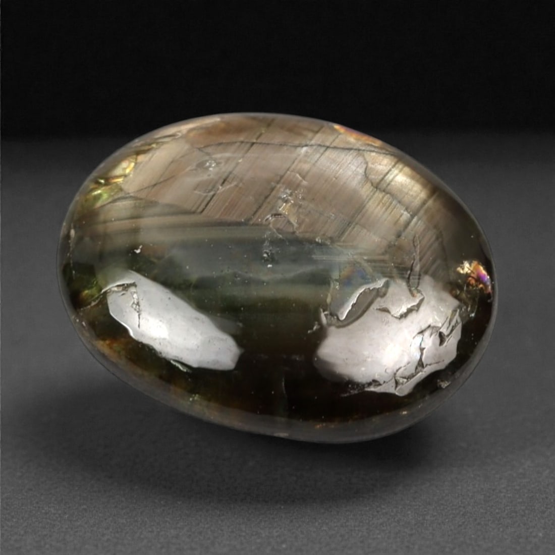 5.28 Carats Gold Sheen Sapphire Cabochon - Natural Burmese Stone, 327A: This exceptional oval cabochon-cut gold sheen sapphire from Burma exhibits a deep, velvety greenish-brown hue, reminiscent of twilight over a forested landscape. The stone is characterized by its stri