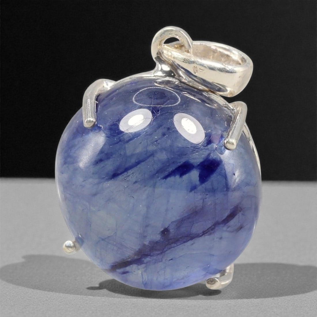 17.17 Carats Deep Blue Sapphire Cabochon Pendant - Sterling Silver Setting, 142A: This striking pendant features a substantial deep blue sapphire cabochon, set in a polished sterling silver frame stamped 925. The cabochon's smooth, domed surface radiates with a rich, velvety blue h