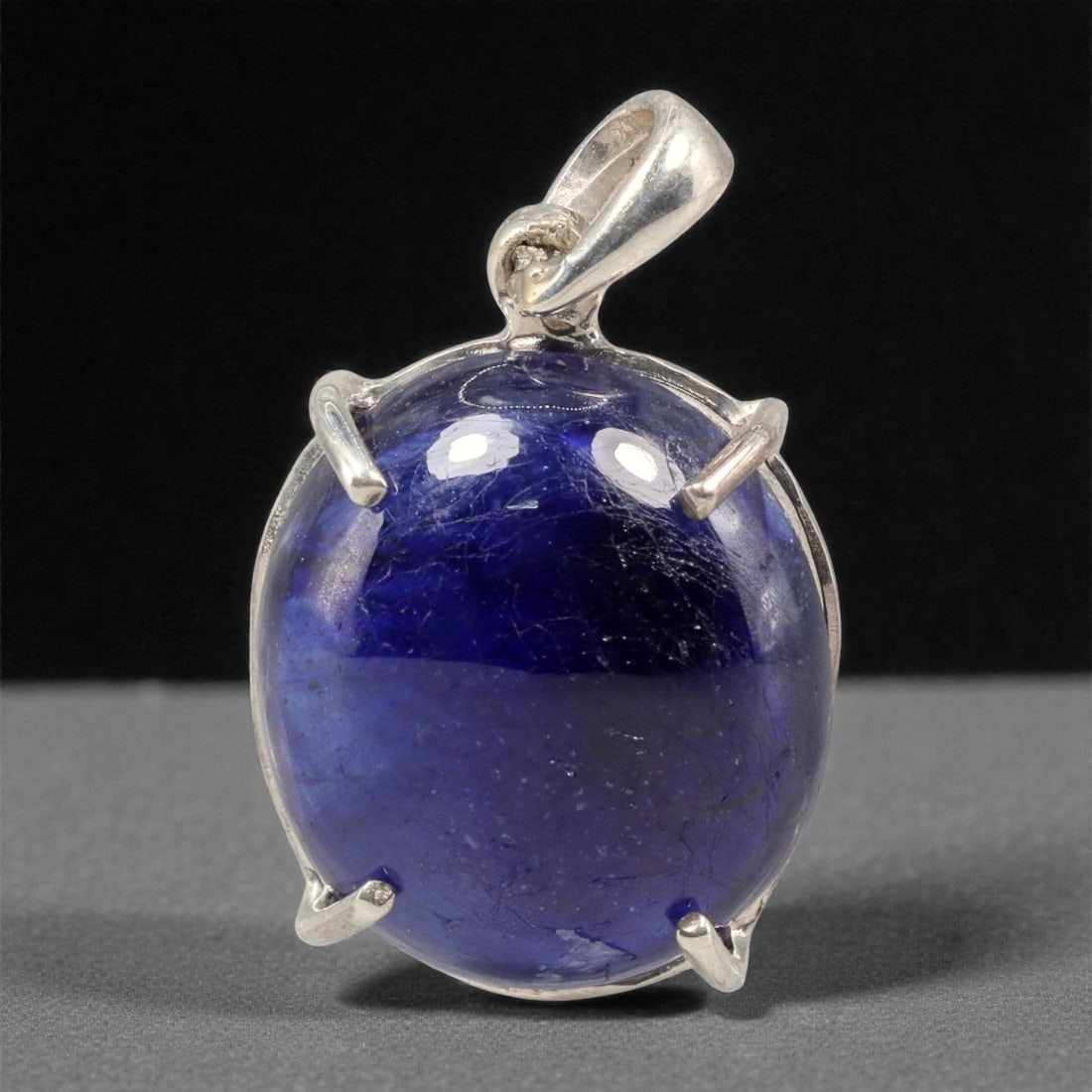 12.62 Carats Deep Blue Sapphire Cabochon Pendant - Sterling Silver Setting, 144A: This striking pendant features a substantial deep blue sapphire cabochon, set in a polished sterling silver frame stamped 925. The cabochon's smooth, domed surface radiates with a rich, velvety blue h