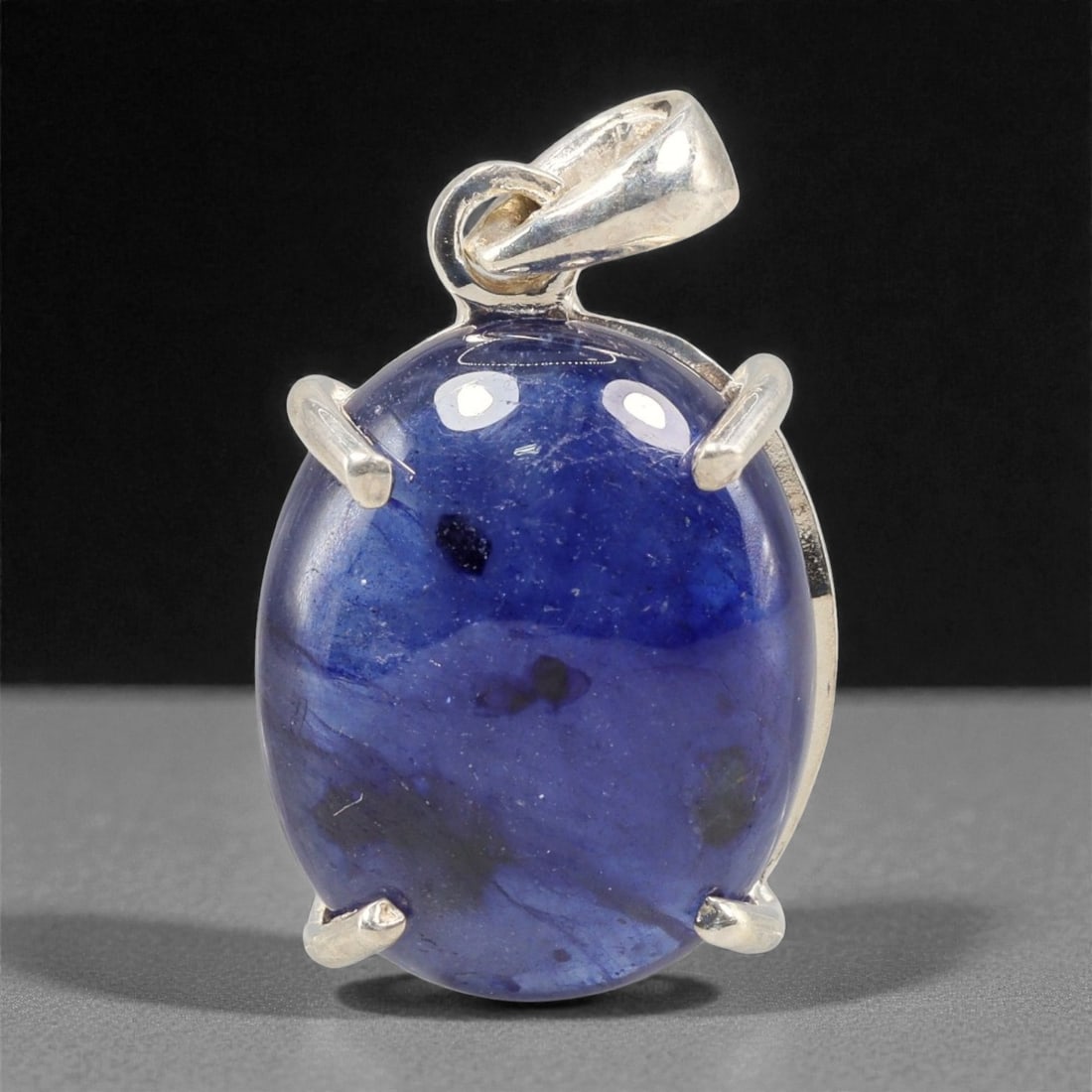 14.52 Carats Deep Blue Sapphire Cabochon Pendant - Sterling Silver Setting, 146A: This striking pendant features a substantial deep blue sapphire cabochon, set in a polished sterling silver frame stamped 925. The cabochon's smooth, domed surface radiates with a rich, velvety blue h