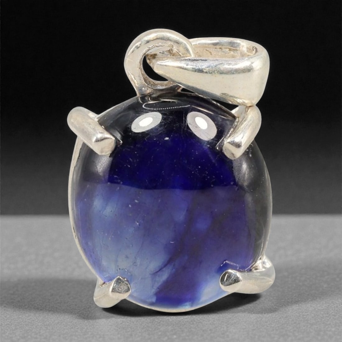 9.31 Carats Deep Blue Sapphire Cabochon Pendant - Sterling Silver Setting, 147A: This striking pendant features a substantial deep blue sapphire cabochon, set in a polished sterling silver frame stamped 925. The cabochon's smooth, domed surface radiates with a rich, velvety blue h