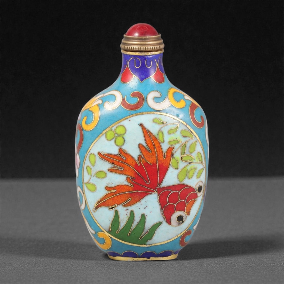 A Chinese Cloisonne Enamel Snuff Bottle, 20th Century, 17YC: Constructed from metal and decorated in cloisonne enamel, the bottle is of flattened ovoid form with gently rounded shoulders tapering to a short cylindrical neck and narrow foot. The surface is artic