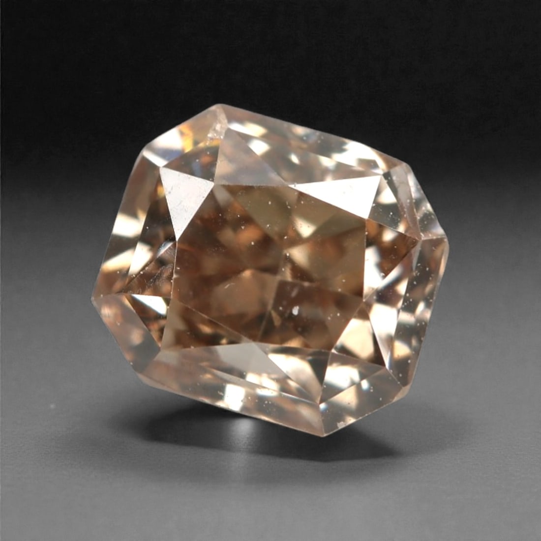 0.65 Carats Fancy Light Brownish Pink Diamond - Natural South African Origin, 9DA: This 0.65 carat fancy light brownish pink diamond captivates with a delicate, peachy-pink hue infused with warm, champagne undertones, creating a soft, romantic glow that is both understated and allur