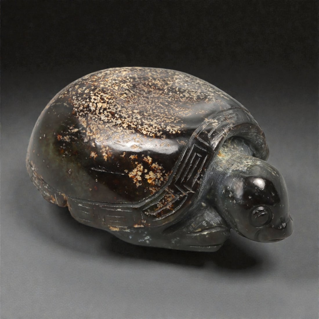 A Chinese Nephrite Jade Tortoise Carving, 20th Century, 91FB: Carved from dark green Hetian nephrite jade with extensive russet and ochre surface inclusions, the sculpture is worked in the round in the form of a tortoise shown in a low, forward-moving posture. T