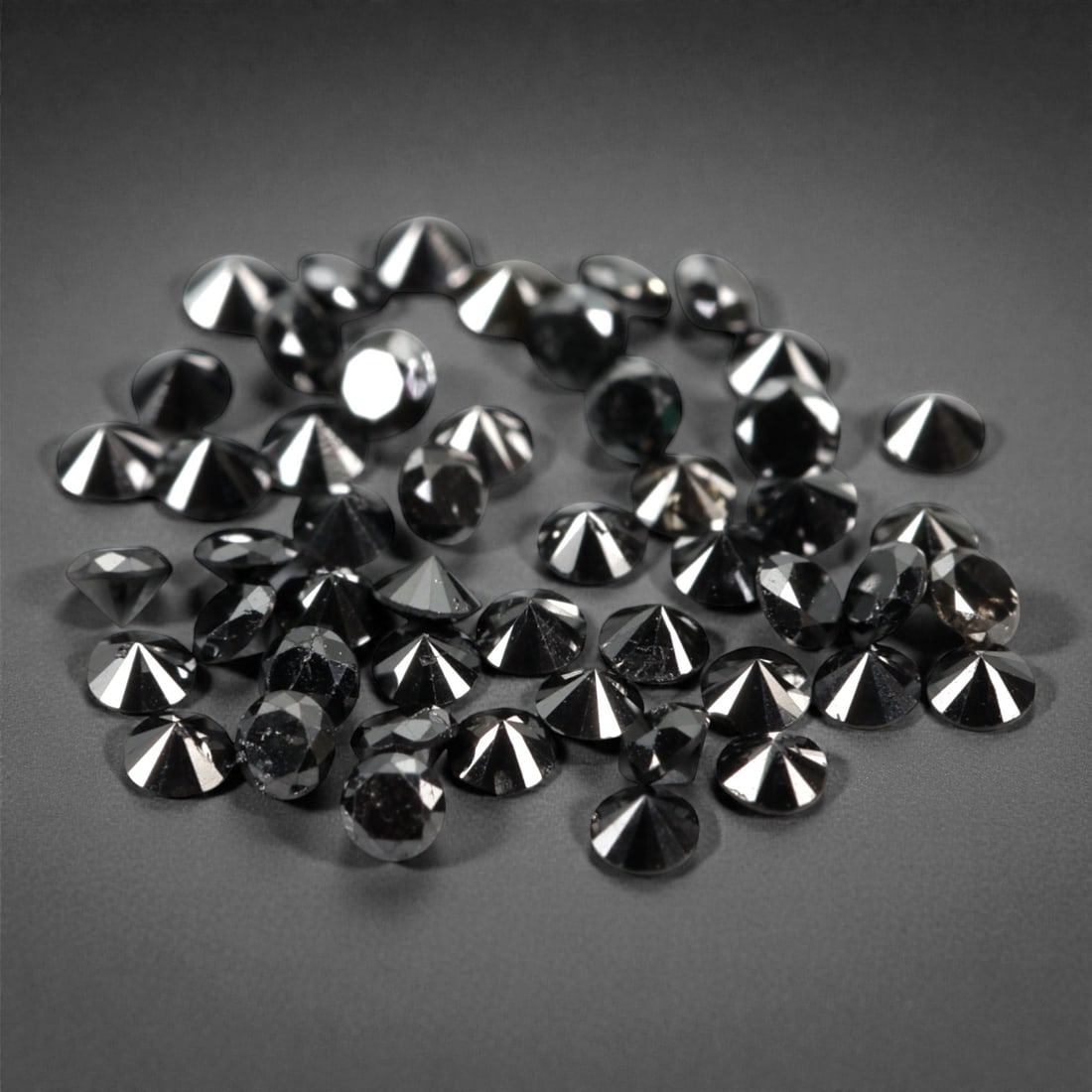50 Pieces Black Diamond Parcel - Round Brilliant Cut, 1.7mm, 162A: This versatile parcel of 50 loose black diamond gems captivates with a deep, opaque black hue that evokes the intensity of polished obsidian and the mystery of a midnight sky. Each stone is cut in a w
