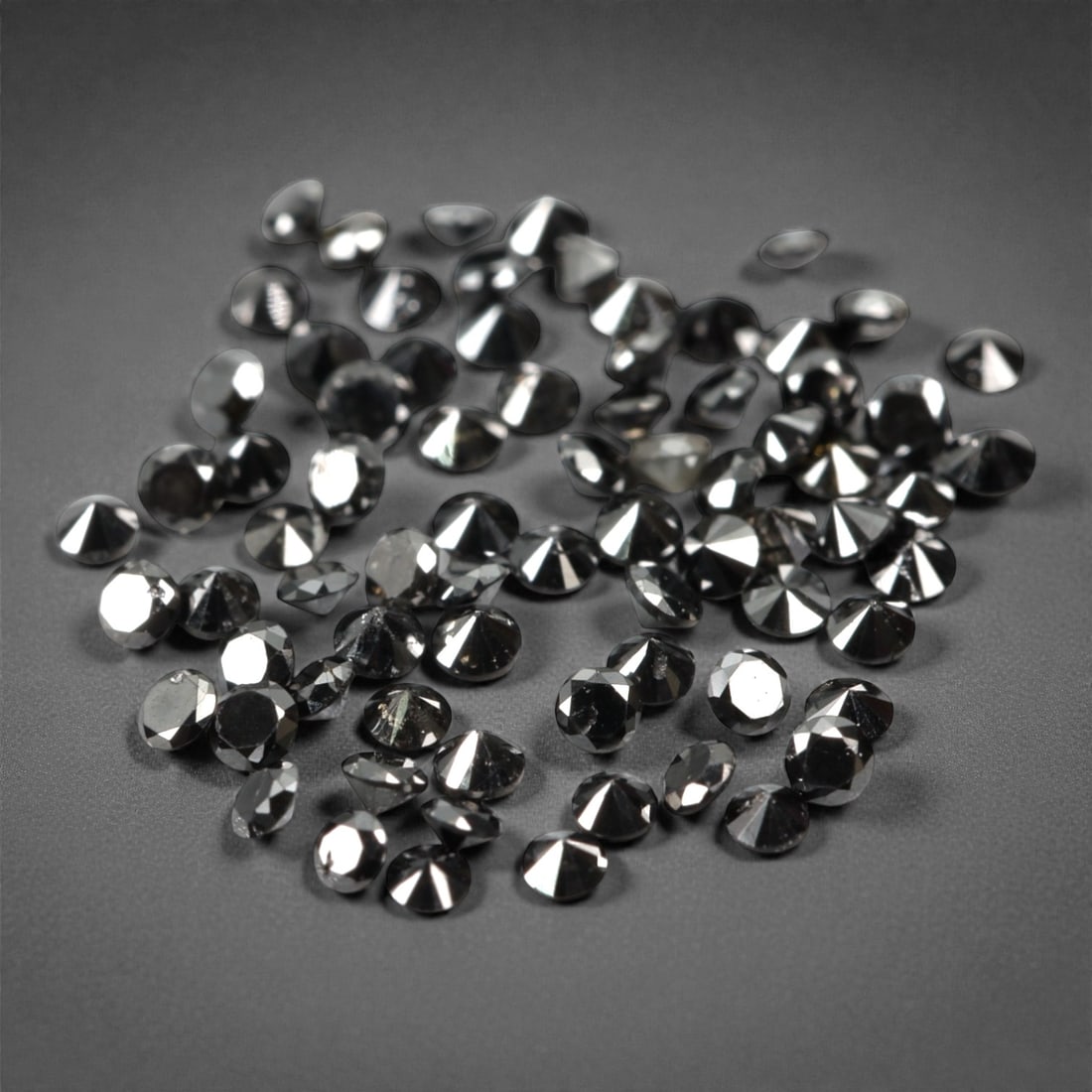 75 Pieces Black Diamond Parcel - Round Brilliant Cut, 1.4mm, 172A: This versatile parcel of 75 loose black diamond gems captivates with a deep, opaque black hue that evokes the intensity of polished obsidian and the mystery of a midnight sky. Each stone is cut in a w