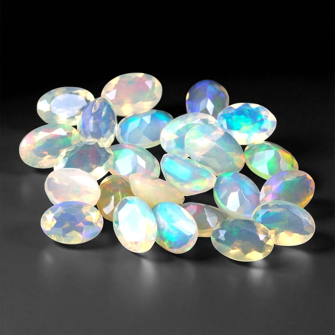 7.05 Carats Oval Cabochon Opal Parcel - Natural Welo Ethiopian Stones, 71XC: This mesmerizing parcel features 6x4 mm oval-cut opals, each glowing with exceptional play-of-color across a luminous, translucent body. Flashes of electric green, oceanic blue, and golden orange shif
