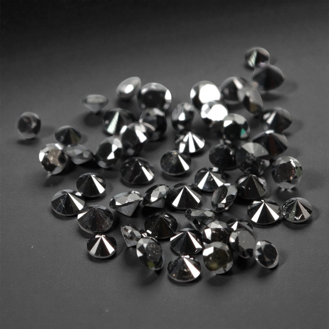 50 Pieces Black Diamond Parcel - Round Brilliant Cut, 1.7mm, 171A: This versatile parcel of 50 loose black diamond gems captivates with a deep, opaque black hue that evokes the intensity of polished obsidian and the mystery of a midnight sky. Each stone is cut in a w