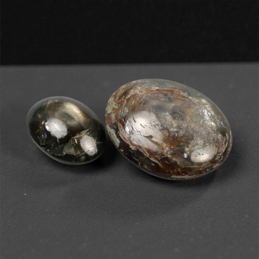 4.24 Carats Gold Sheen Sapphire Selection - Natural Burmese Stones, 318A: This curated selection of two cabochon-cut gold sheen sapphires captivates with a rich, earthy palette of deep green and brown tones, accented by a luminous metallic sheen that shimmers across their s