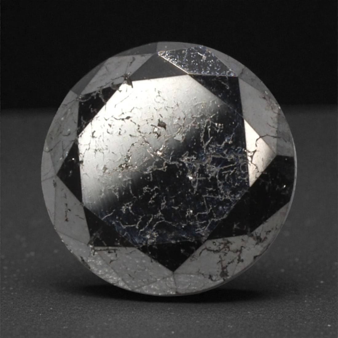 1.77 Carats Black Diamond - Round Brilliant Cut, 297A: This substantial black diamond captivates with a deep, opaque black hue that evokes the intensity of polished obsidian and the mystery of a midnight sky. Cut in a well-proportioned round brilliant sha