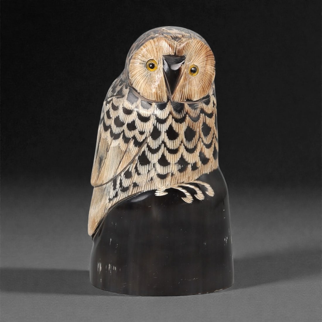 An East Asian Ox Horn Owl Effigy, 20th Century, 8FJ: Carved from a single section of ox horn with pronounced natural color gradation from pale beige to deep brown, the object is formed as a standing owl rendered in the round. The head is modeled with a
