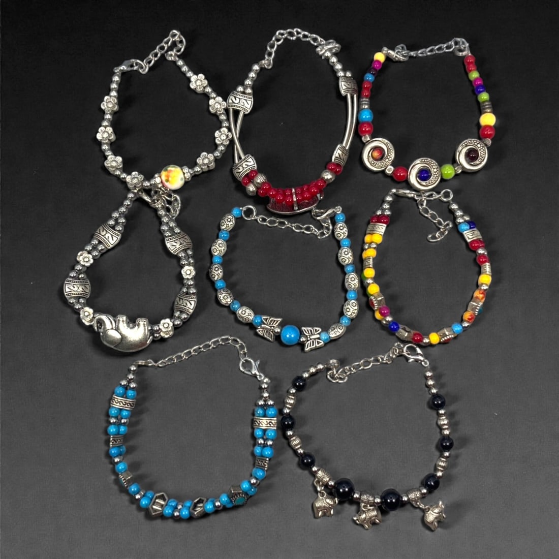 A Group of Eight Silver-Tone and Beaded Bracelets, Late 20th-Early 21st Century, 39ZG: The group comprises eight bracelets constructed with silver-tone metal components and assorted glass or composite beads. The designs vary across the group and include floral-form spacers, tubular and