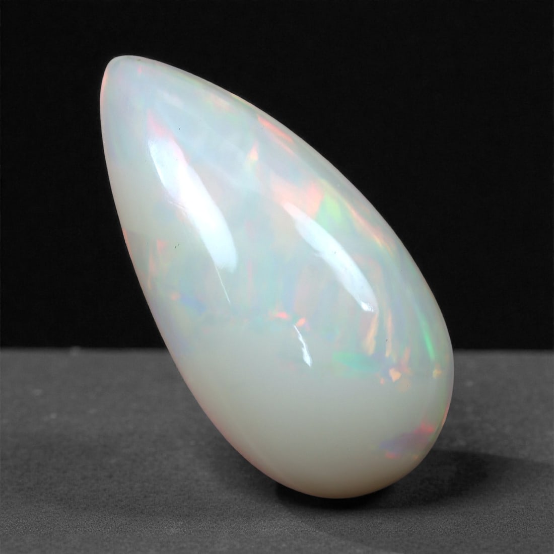 7.67 Carats Flaming Rose Welo Opal - Natural Ethiopian Gemstone 21.4x10.9x7.1mm, 7XH: This dramatic Welo opal captivates with sweeping flashes of rose-pink, peach, and lime green dancing through a soft ivory body. Its elongated form enhances the gem's internal movement, revealing strea