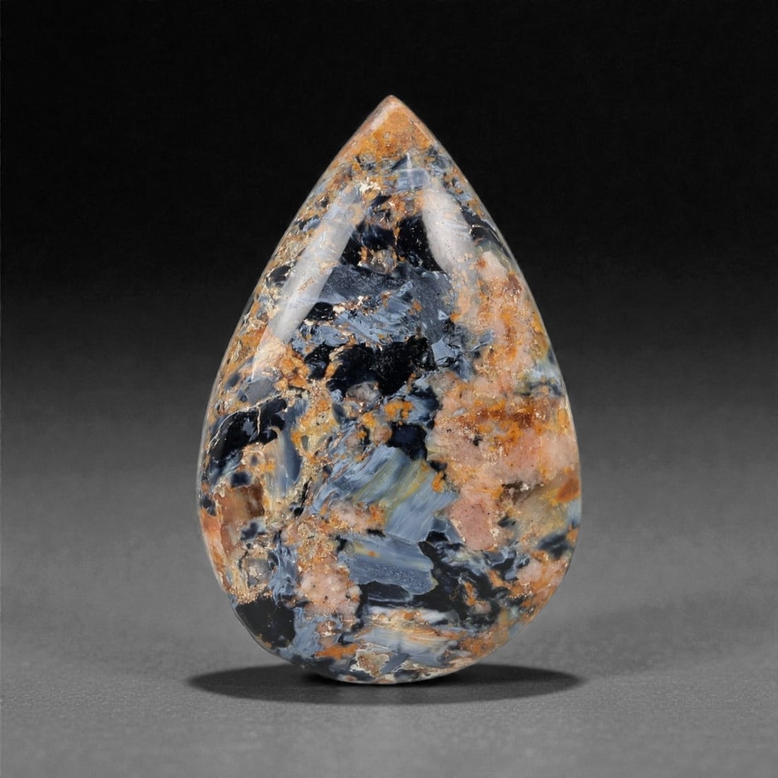 46.49 Carats Multicolor Pietersite Cabochon - Natural Namibian Stone - 37.2 x 24.4 x 8 mm, 24XK: This dramatic pietersite cabochon bursts with a swirling mosaic of navy, ochre, rose, and slate-blue hues, evoking the appearance of a cosmic storm frozen in stone. The high-polish teardrop cut amplif