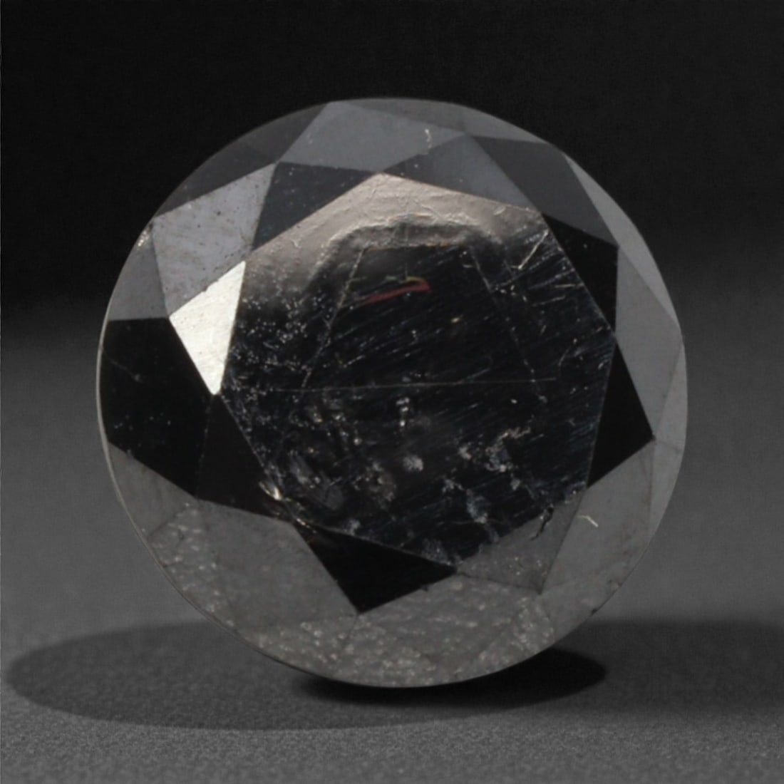 1.57 Carats Black Diamond - Round Brilliant Cut, 295A: This substantial black diamond captivates with a deep, opaque black hue that evokes the intensity of polished obsidian and the mystery of a midnight sky. Cut in a well-proportioned round brilliant sha