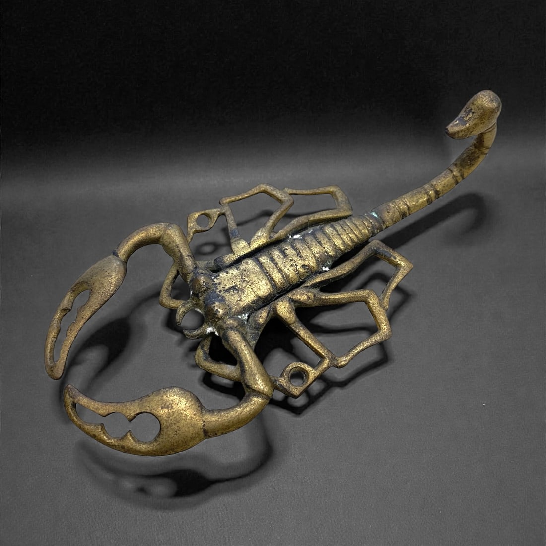 A Mid Century Bronze Scorpion, 167g, 97AA: Cast in bronze, the sculpture depicts a scorpion in a naturalistic, openwork form. The creature is rendered with detailed incised lines defining its segmented body, jointed legs, and large pincers, wh