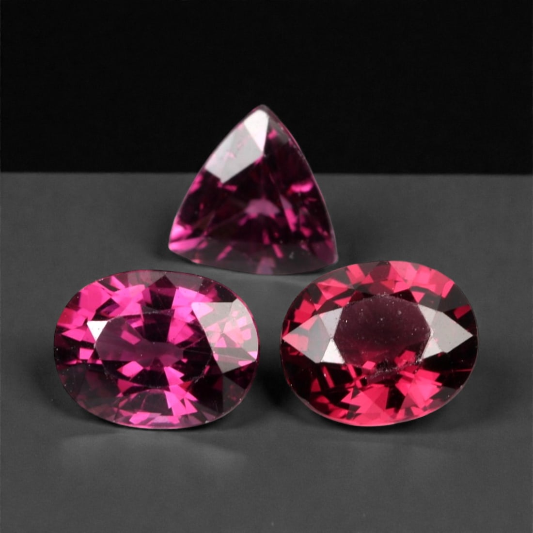 3.18 Carats Deep Raspberry Rhodolite Garnet Selection - Natural Mozambican Stones, 364A: This curated selection of three rhodolite garnets captivates with a deep, velvety raspberry hue, reminiscent of ripe summer berries and rich red wine. Each stone is precision-faceted to maximize light