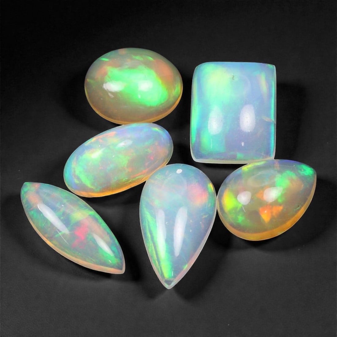9.90 Carats Multicolor Welo Opal Selection - Natural Ethiopian Stones, 10-13mm, 15XK: A kaleidoscope of shifting fire dances across this glowing selection of Welo opals, offering flashes of electric green, neon pink, oceanic blue, and sunlit orange. The stones exhibit that signature et