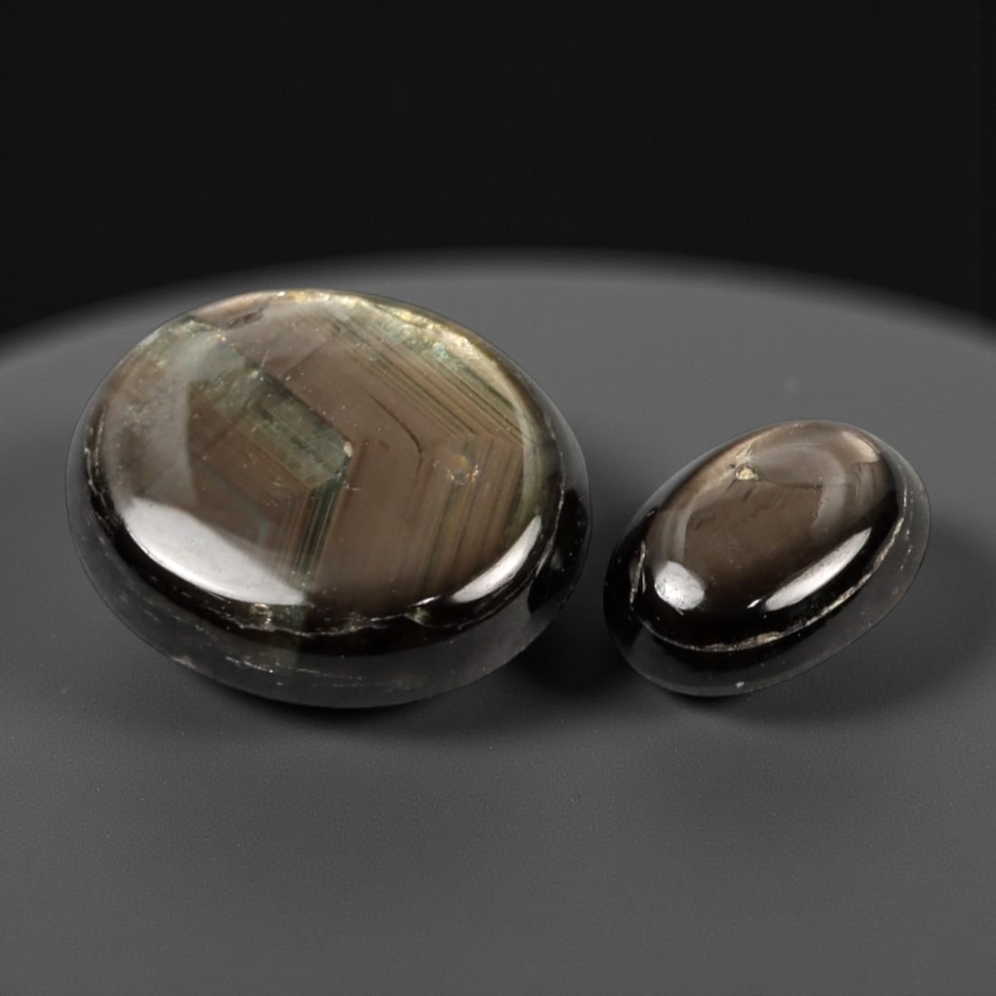 4.31 Carats Earth Tone Star Sapphire Selection - Natural Ceylon Origin, 305A: This curated selection of two cabochon-cut star sapphires showcases the understated, natural beauty of these gemstones, with a muted, earthy palette of deep brown and subtle greenish tones. Each smoot