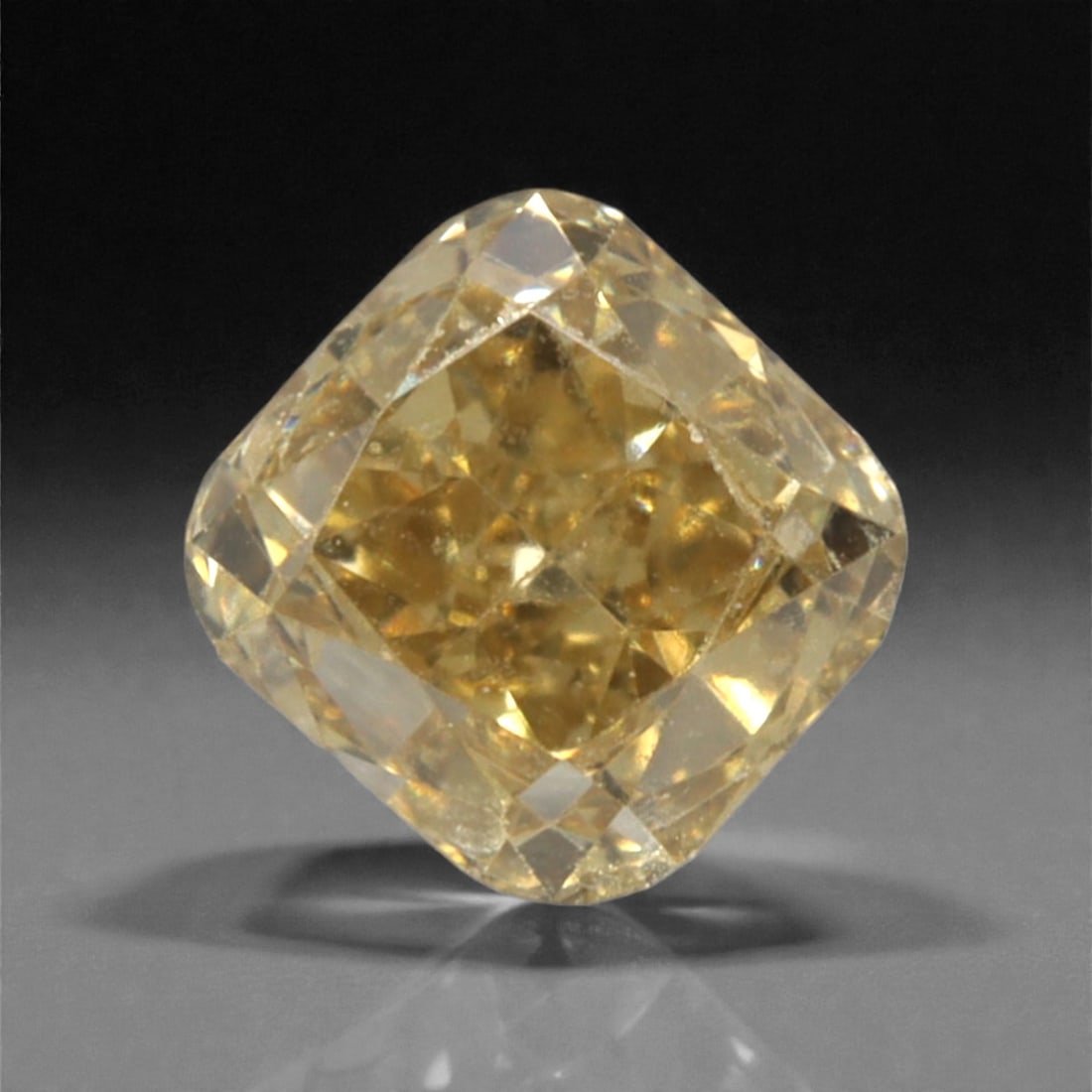 0.18 Carats Fancy Light Yellow Diamond - Natural South African Origin, 34DA: This 0.18 carat fancy light yellow diamond glows with a soft, buttery hue reminiscent of sun-warmed honey, its cushion modified brilliant cut amplifying a gentle, luminous sparkle across every facet.