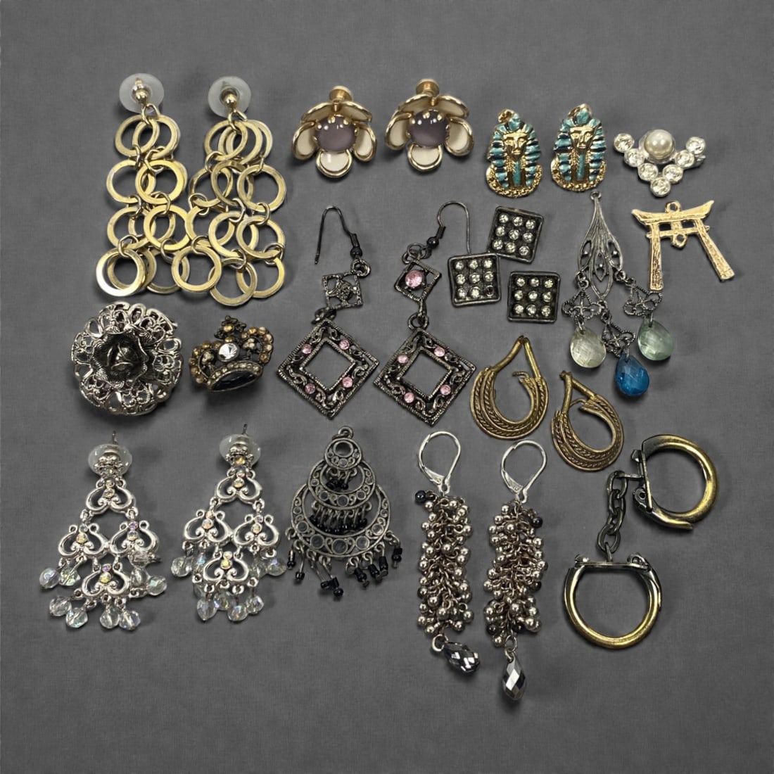 An Estate Lot of Earrings and Two Brooches, Late 20th Century, 96FK: The lot comprises earrings and brooches, crafted from gilt and silver-toned alloy, with glass, crystal, enamel, and faux pearl accents. The pieces include: multi-tiered openwork gilt hoop earrings; fl