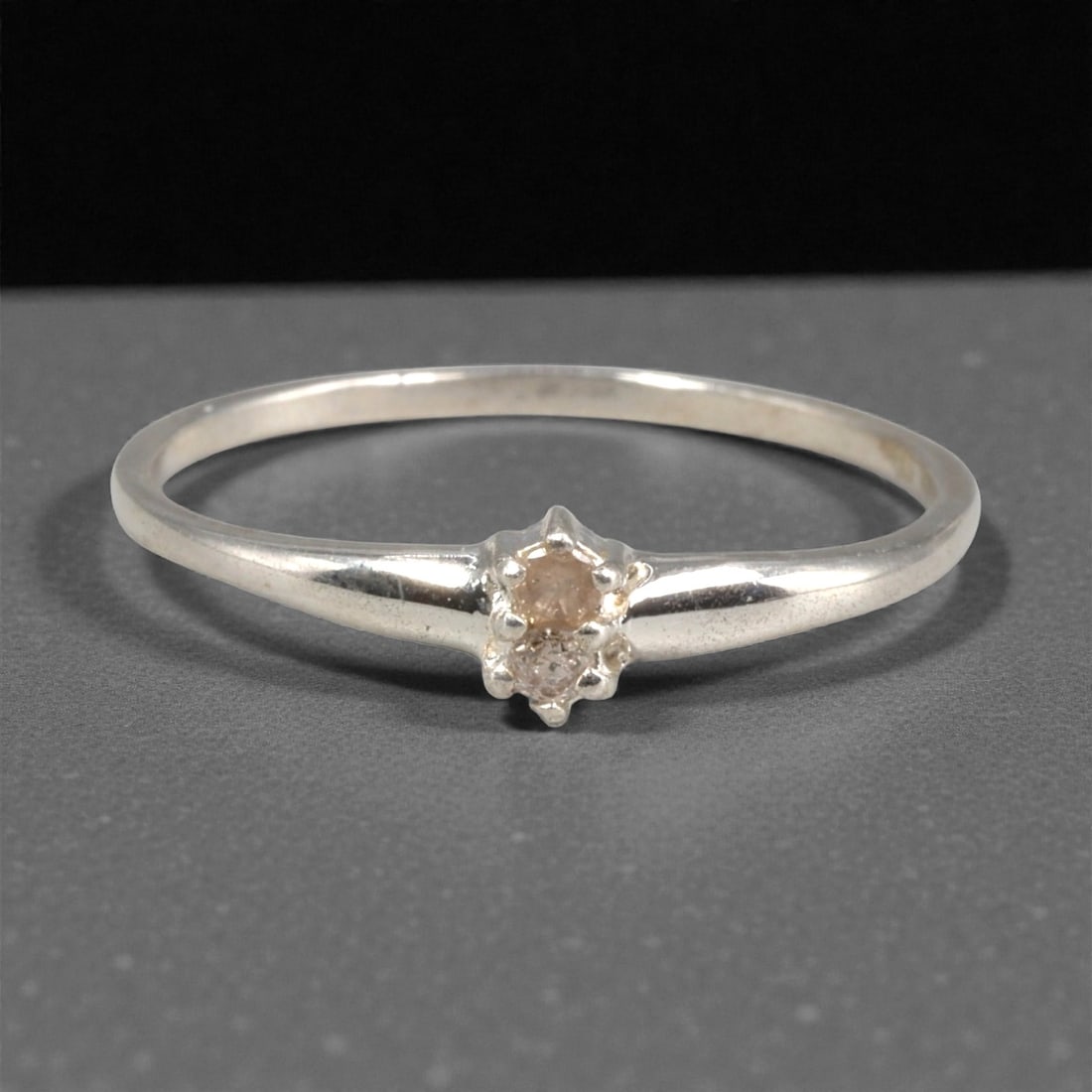 Sterling Silver (925) Ring with Two Diamonds - Size 6 US, 123A: This delicate ring is crafted from polished sterling silver (stamped 925), featuring a slender, tapered band that culminates in a dual-stone setting. The design centers on two small, round-cut diamond