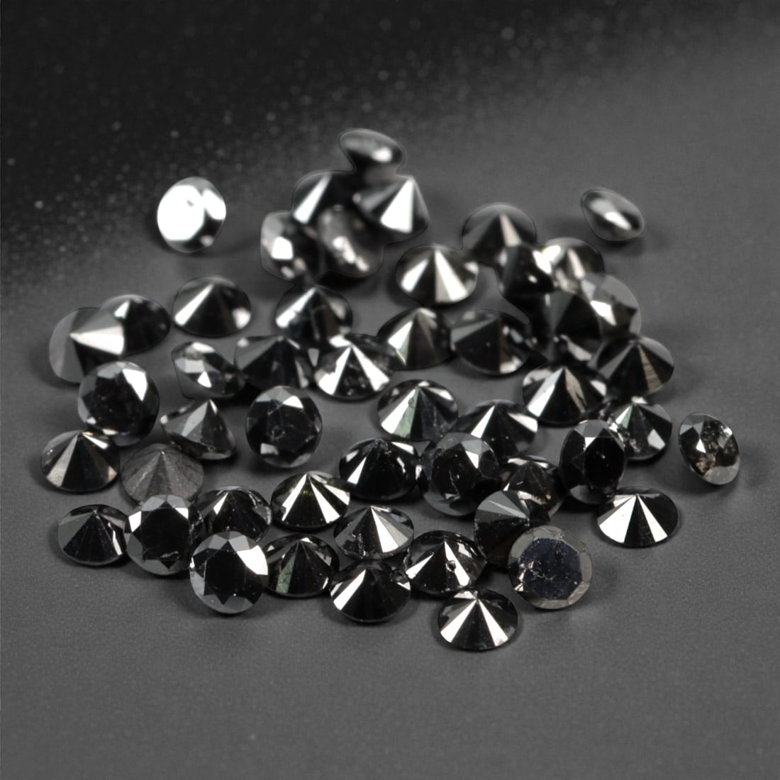50 Pieces Black Diamond Parcel - Round Brilliant Cut, 1.7mm, 164A: This versatile parcel of 50 loose black diamond gems captivates with a deep, opaque black hue that evokes the intensity of polished obsidian and the mystery of a midnight sky. Each stone is cut in a w