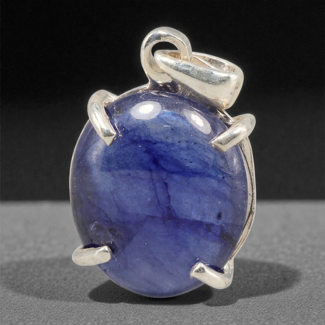 12.13 Carats Deep Blue Sapphire Cabochon Pendant - Sterling Silver Setting, 153A: This striking pendant features a substantial deep blue sapphire cabochon, set in a polished sterling silver frame stamped 925. The cabochon's smooth, domed surface radiates with a rich, velvety blue h