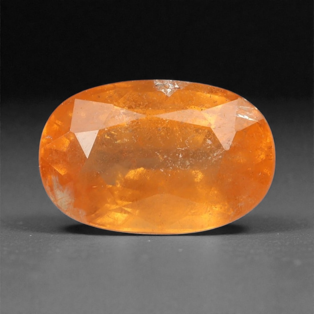 2.83 Carats Golden Orange Spessartite Garnet - Natural Namibian Stone - 9.4 x 6.1 x 4.7 mm, 42XK: Glowing with the warmth of golden embers, this oval-cut spessartite garnet radiates a vibrant orange hue touched with amber undertones. The gem's internal fire is enhanced by a well-executed cut that