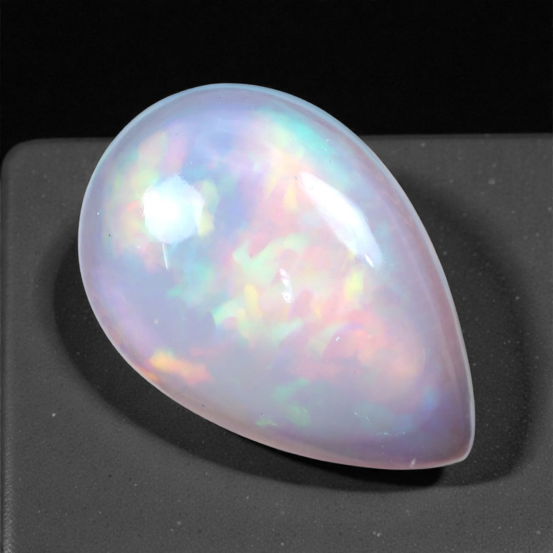 5.17 Carats Confetti Light Welo Opal - Natural Ethiopian Gemstone 16.7x11.4x5.6mm, 13XH: This luminous Welo opal shimmers with a soft cascade of pastel fire, revealing flashes of mint, lavender, peach, and lemon yellow dancing beneath a creamy translucent surface. The play-of-color appear