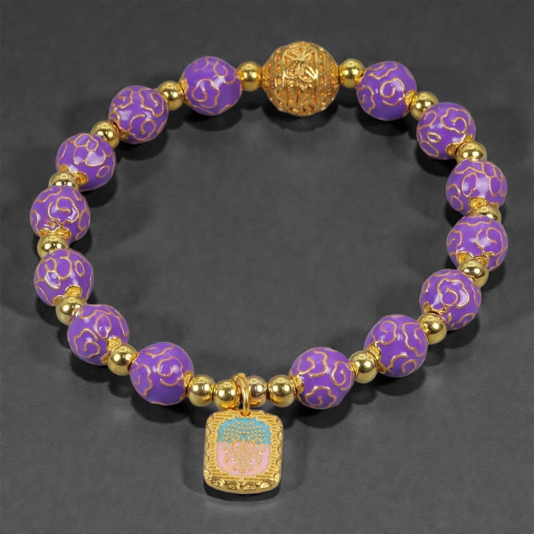 A Chinese Cloisonne Enamel Bracelet, 20th-21st Century, 85YB: Formed as a circular bracelet composed of spherical cloisonne enamel beads alternating with small gilt metal spacers. The beads are decorated with opaque purple enamel grounds, articulated with fine g