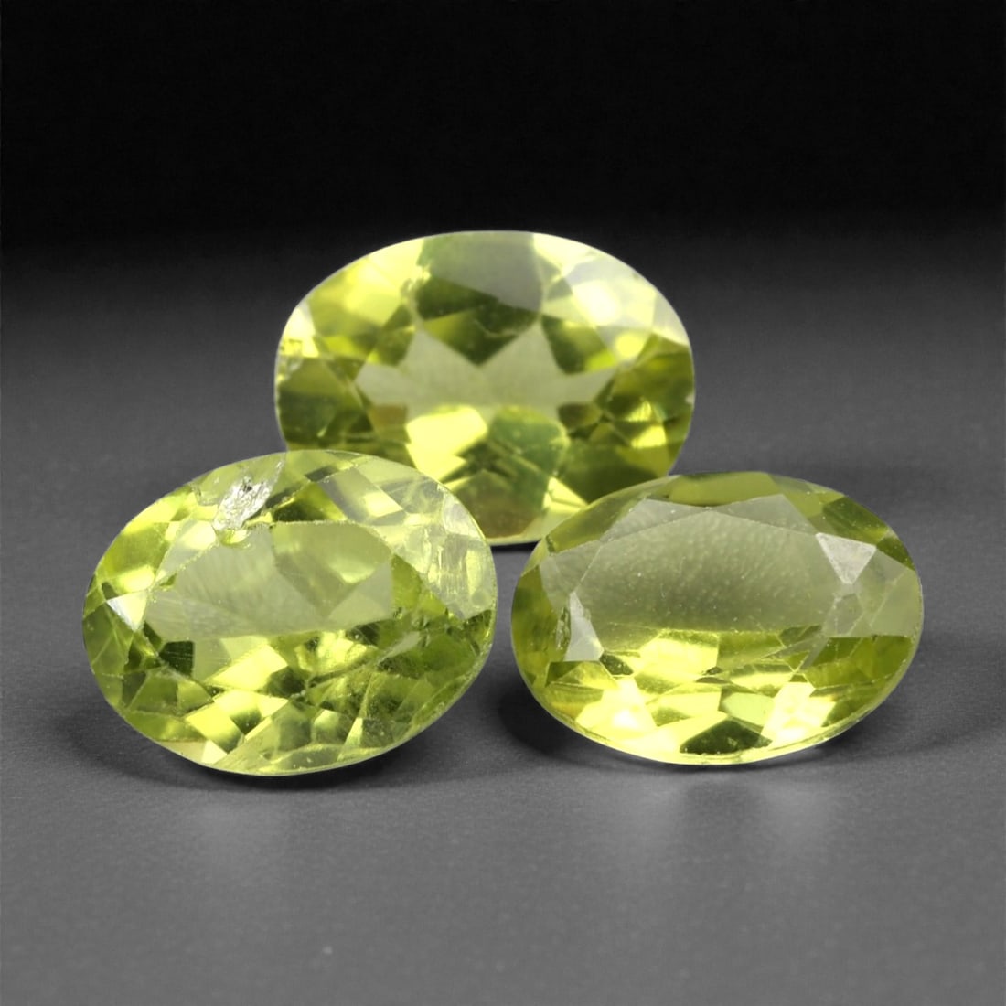 4.00 Carats Bright Green Peridot Parcel - Natural Pakistani Stones, 329A: This vibrant parcel of three loose peridot gems dazzles with a bright, grassy green hue that evokes the lush vibrancy of fresh foliage. Each stone is cut in a well-proportioned oval shape, with facete