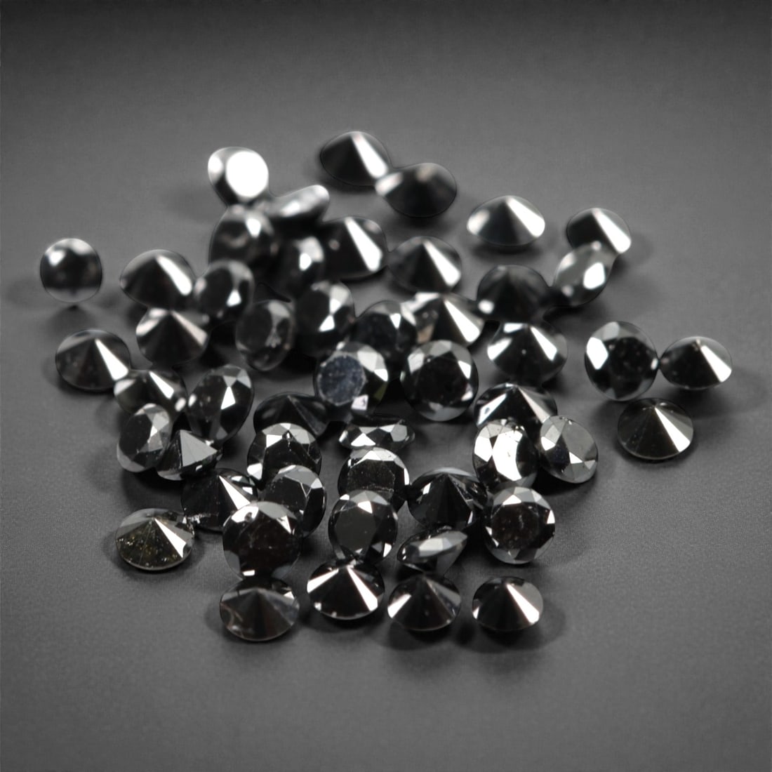 50 Pieces Black Diamond Parcel - Round Brilliant Cut, 1.7mm, 177A: This versatile parcel of 50 loose black diamond gems captivates with a deep, opaque black hue that evokes the intensity of polished obsidian and the mystery of a midnight sky. Each stone is cut in a w