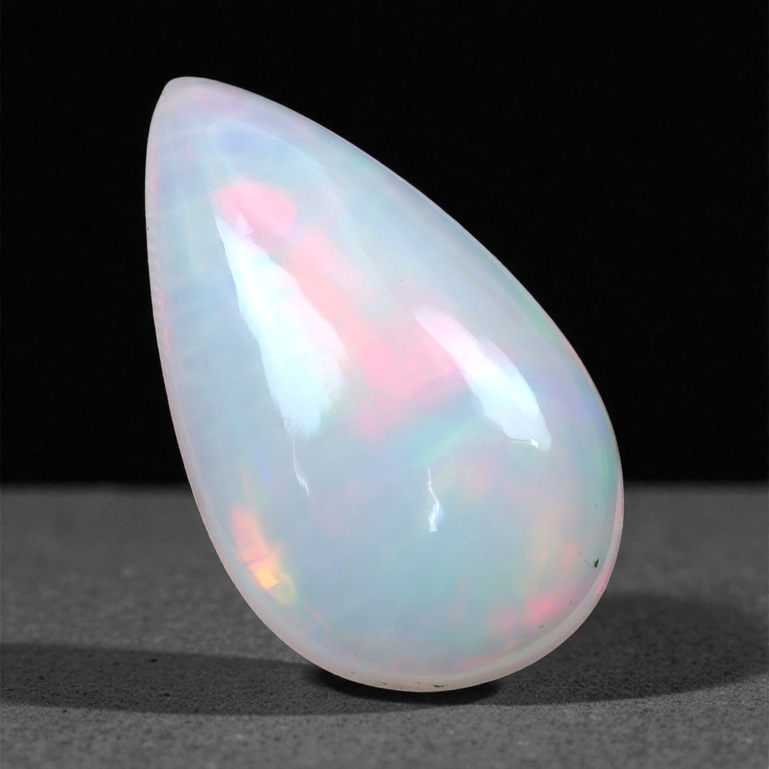 3.34 Carats Pastel Play-of-Color Opal - Natural Ethiopian Stone 15.6x9.3x5.2mm, 28XH: This softly luminous Welo opal presents a dreamy blend of pastel hues-blush pink, mint green, and soft lavender-glowing beneath its milky white surface. The pear-shaped cabochon is smoothly contoured