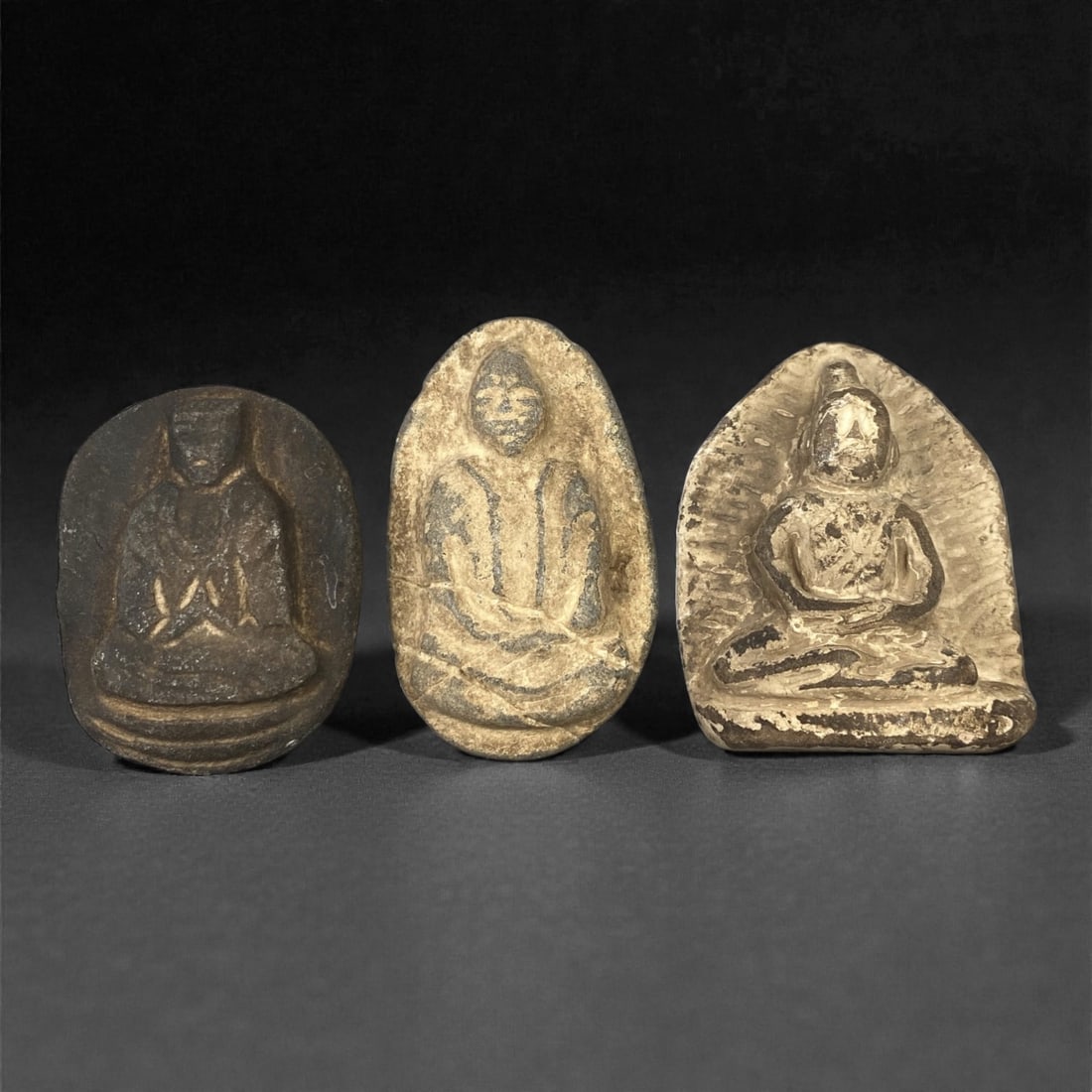 A Group of Three Edo Period Buddhist Stone Carving Reliefs, 17th-19th Century, 63FM: Comprising three stone carving reliefs, each formed from naturally shaped or cut stone with visible surface patina and tonal variation. The leftmost relief depicts a seated Buddhist figure in meditati
