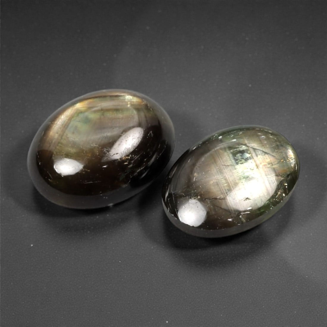 4.95 Carats Dark Greenish Brown Star Sapphire Parcel - Natural Sri Lankan Stones, 369A: This striking parcel of two loose star sapphires captivates with their deep, earthy greenish-brown hues and the subtle, luminous asterism that emerges under direct light. The smooth, cabochon-cut surf