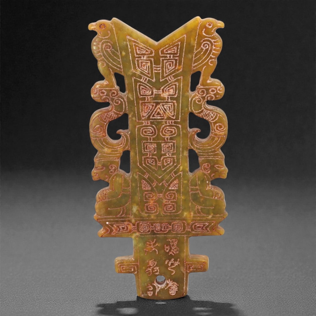 A Chinese Hetian Jade Archaistic Openwork Plaque, 20th Century, 59FH: Carved from mottled olive-green and russet-toned Hetian nephrite jade, the plaque is vertically oriented and worked in an archaistic style recalling early ritual jades. The composition is symmetrical,