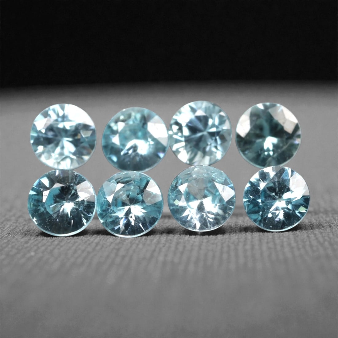 3.04 Carats Sky Blue Zircon Parcel - Natural Sri Lankan Stones, 356A: This luminous parcel of nine loose zircon gems dazzles with a soft, sky-blue hue that evokes the clarity of a bright, open sky. Each stone is cut in a well-proportioned round brilliant shape, with fac