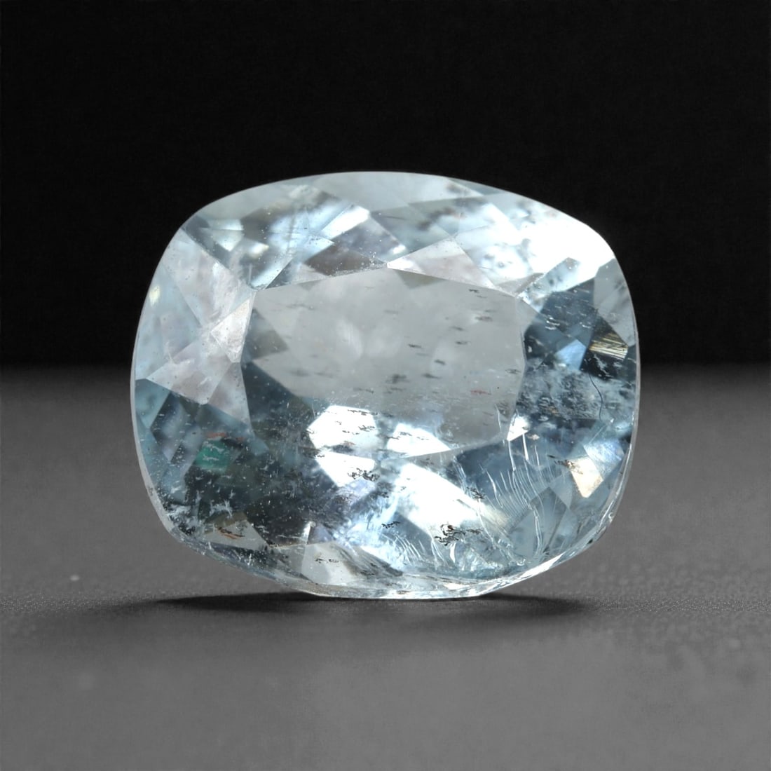 3.91 Carats Light Blue Brazilian Aquamarine Cushion Cut - 10.8 x 9.1 x 6.4 mm, 62XK: This substantial aquamarine displays a serene light blue hue with cool, watery tones that evoke clarity and openness. The cushion cut emphasizes broad facet reflections, giving the stone a calm glow a
