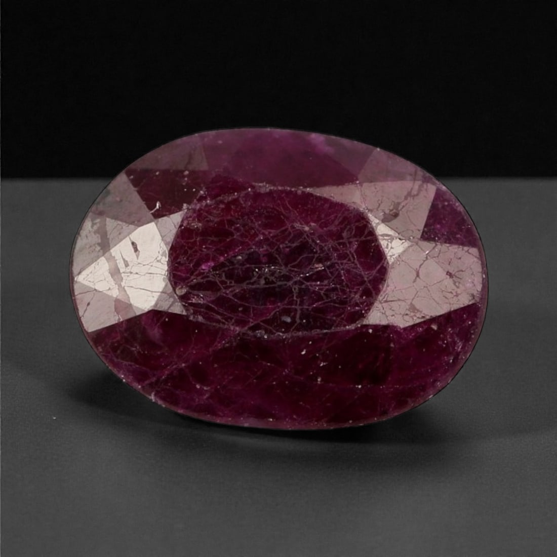 1.47 Carats Deep Crimson Ruby - Natural Mozambique 8.1 x 6.1 x 3.5 mm, 39WC: This richly saturated ruby captivates with its deep crimson hue and classic oval silhouette. The gem's surface reveals a mosaic of internal character, with reflective facets adding depth and intrigue