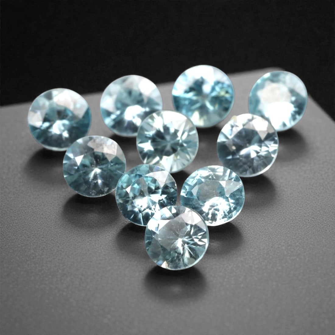 3.11 Carats Sky Blue Zircon Parcel - Natural Sri Lankan Stones, 348A: This luminous parcel of ten loose zircon gems dazzles with a soft, sky-blue hue that evokes the clarity of a bright, open sky. Each stone is cut in a well-proportioned round brilliant shape, with face