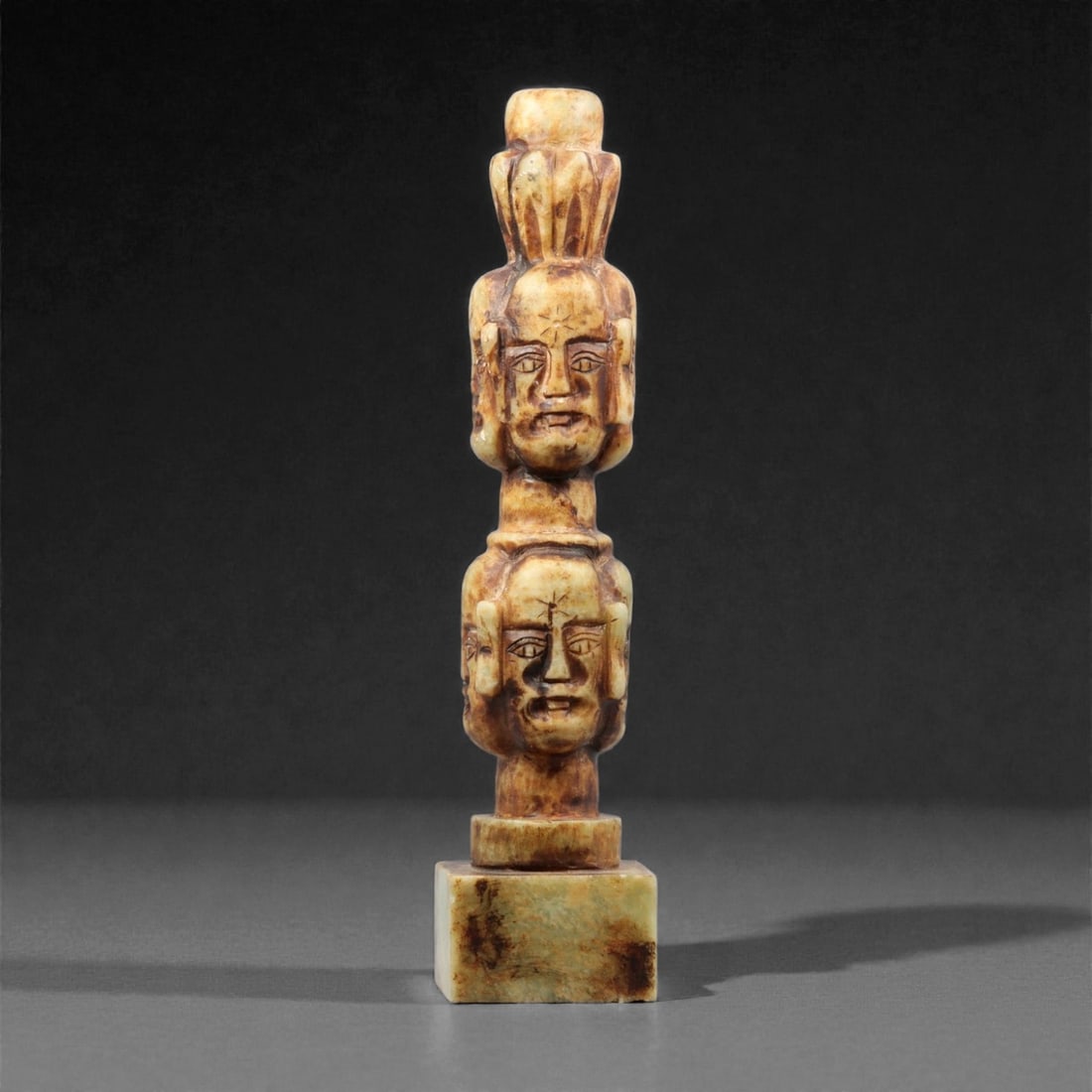 A Chinese Jade Stamp Seal, 19th-20th Century, 49YC: The seal is carved from jade with variegated brown and cream tones, the stone showing natural inclusions and color transitions. It is worked in the form of a tall rectangular shaft surmounted by a scu
