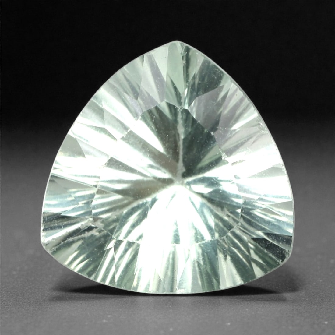 4.18 Carats Pale Green Fluorite Trillion - Natural Mexican Stone, 350A: This luminous pale green fluorite gem captivates with a soft, milky green hue that evokes the tranquility of frosted glass and the gentle glow of moonlight. Cut in a well-proportioned trillion shape,