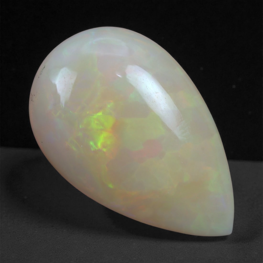 5.81 Carats Play-of-Color Welo Opal - Natural Ethiopian Gem 18x11mm, 89XA: This captivating Welo opal gleams with a luminous cascade of multi neon color that ripple across the stone's surface with every movement. The play-of-color is vivid and well-distributed, presenting a